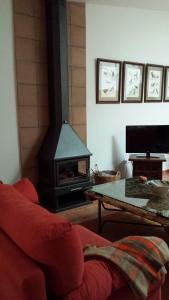 Una sala de estar con un sofá rojo y una chimenea. en Agroturismo la finka, en Los Quiles