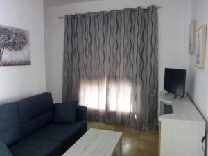 a living room with a couch and a window at APARTAMENTO PUERTA SEVILLA in Carmona