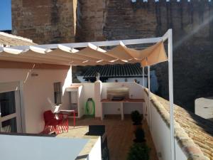 a patio with a white umbrella on top of a house at APARTAMENTO PUERTA SEVILLA in Carmona