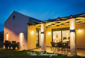 a house with a patio with a table and chairs at Villa Archangelos in Archángelos