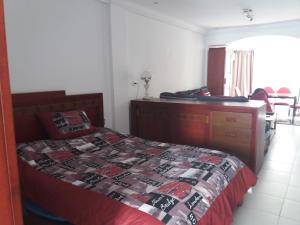 ein Schlafzimmer mit einem Bett und einer Kommode und einem Bett sidx sidx sidx sidx in der Unterkunft studio cosy au lac 1 en face du Movenpick Hotel in Berges Du Lac