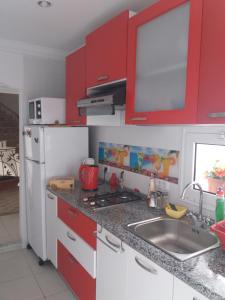 a kitchen with red cabinets and a sink at studio cosy au lac 1 en face du Movenpick Hotel in Berges Du Lac