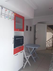 a kitchen with red cabinets and a table in a room at studio cosy au lac 1 en face du Movenpick Hotel in Berges Du Lac