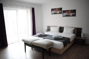 a bedroom with two beds and a large window at Bruno Apartment in Cluj-Napoca