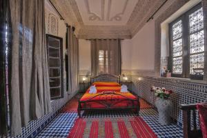 a bedroom with a red bed in a room at Riad Hala in Fès