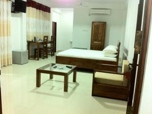 1 dormitorio con cama y mesa de centro en Gem Field Rest, en Ratnapura