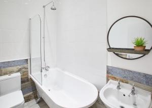 La salle de bains est pourvue d'un lavabo, de toilettes et d'un miroir. dans l'établissement Host & Stay - The Surfer's Loft Apartment, à Saltburn-by-the-Sea