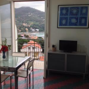 a living room with a table and a television and a window at Chloé in Levanto