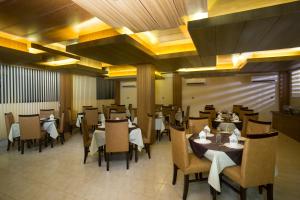 uma sala de jantar com mesas e cadeiras num restaurante em Memento Residence em Daca