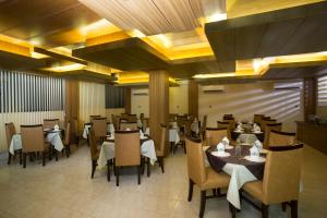 a dining room with tables and chairs in a restaurant at Memento Residence in Dhaka