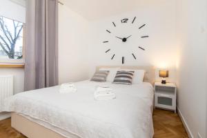 a bedroom with a bed with a clock on the wall at Apartment Platinium I in Białystok