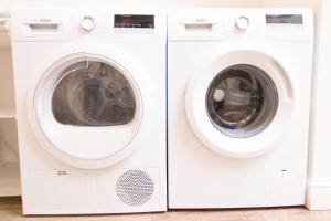 twee witte wasmachines naast elkaar bij Bellavista Lux Ground Floor Apt in Florence