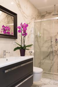 a bathroom with a sink and a shower with purple flowers at Bellavista Lux Ground Floor Apt in Florence