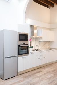 a white kitchen with a refrigerator and a microwave at Bellavista Lux Ground Floor Apt in Florence