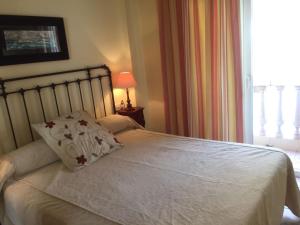 a bedroom with a bed with a pillow and a window at Precioso piso frente al mar con enorme terraza in El Campello