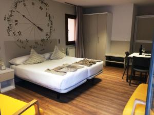 a bedroom with a bed with a large clock on the wall at Apartamentos Turísticos Pueri Cantores in Burgos