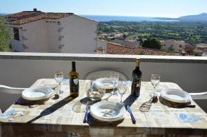 una mesa con dos botellas de vino y copas en Appartamento Li Puntiti 2, en Budoni
