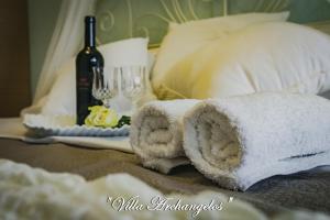 a towel sitting on a bed with a bottle of wine at Villa Archangelos in Archángelos