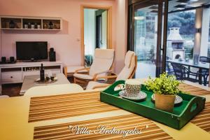 a living room with a table with a green tray at Villa Archangelos in Archángelos