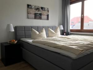Un dormitorio con una cama con almohadas blancas y una ventana en Best Apartments, en Bad Salzuflen