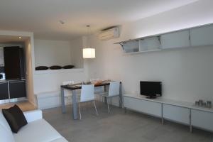 cocina y sala de estar con mesa y sillas en Residence Ormeggio, en Grado