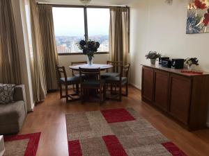 sala de estar con mesa, sillas y ventana en Departamento 8 Norte, Torre del Mar, en Viña del Mar