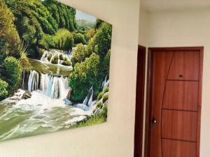 a painting of a waterfall hanging on a wall at Hotel Olivier in Três Rios