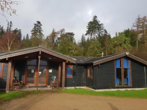 Cabaña de madera con porche y ventanas en Shore Lodge, en Brodick