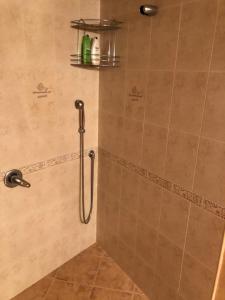 La salle de bains est pourvue d'une douche avec un pommeau de douche. dans l'établissement Ambrozia Spa and Relax family house, à Batchkovo