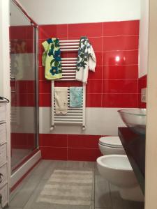 a red bathroom with a toilet and a sink at La Casa Di Nena in Vivo dʼOrcia +35 photos