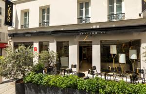 un bâtiment avec des chaises et des tables devant lui dans l'établissement Hotel Du Cadran, à Paris