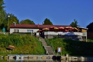 a building with stairs and umbrellas next to a river at Mobilheime in Klaffer am Hochficht