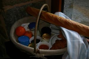 una cesta con pan y otros alimentos. en Ferme Saint Christophe en Saint-Marcan