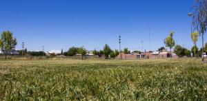 a field of green grass with houses in the background at La Quintina in Allen