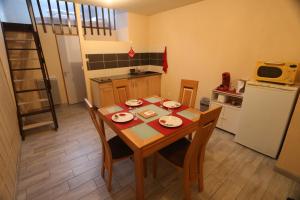 a kitchen with a table and chairs and a kitchen with a refrigerator at Apparts Gites Cholet centre in Cholet