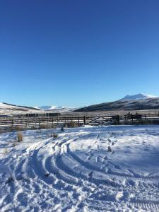 a snow covered field with a fence in the background at Ledgowan Bunkhouse in Achnasheen