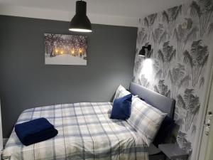 a bedroom with a bed with blue pillows on it at Chatterley House in Nottingham