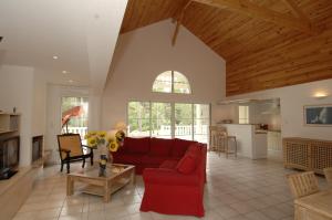 a living room with a red couch and a kitchen at Lagrange Vacances - Atlantic Green in Lacanau-Océan