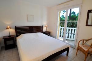 a bedroom with a large bed and a balcony at Lagrange Vacances - Atlantic Green in Lacanau-Océan