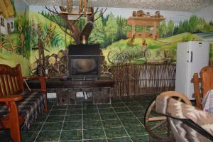 a living room with a fireplace and a painting on the wall at Kvitkovyi Rai З червня басейн з підігрівом 10 на 5 метрів in Slavske