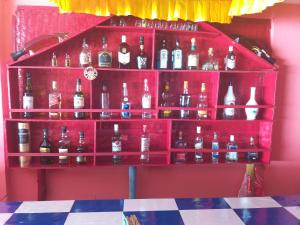 un estante rojo lleno de botellas de alcohol en Royal Wood Beach Resort, en Palolem