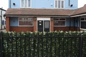 a house with a fence in front of it at Xtasia Adult Hotel - Adults Only in West Bromwich