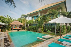 a swimming pool in front of a villa at Mayo Resort in Umeanyar