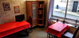 Habitación con mesa roja y ventana en Hôtel de la Gare, en Morlaix