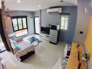 uma sala de estar com um sofá e um frigorífico num quarto em The Endless Bangtao Residence LOFT 7 em Bang Tao Beach