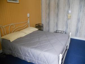 a white bed in a room with a window at Hôtel de la Gare in Morlaix