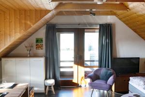 a living room with a purple chair and a tv at Stolzing-Apart in Bayreuth