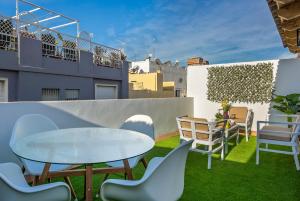 a patio with a table and chairs on a balcony at Genteel Home Galera in Seville