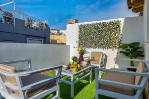 a patio with two chairs and a table on a balcony at Genteel Home Galera in Seville