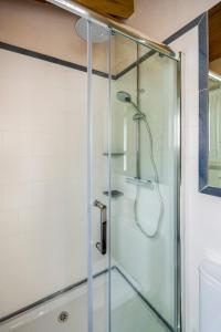 a shower with a glass door in a bathroom at Genteel Home Galera in Seville